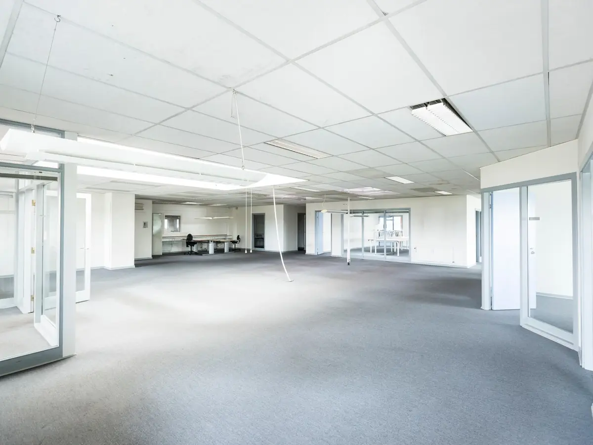 Empty open-plan office with glass partitions ready to be reconfigured