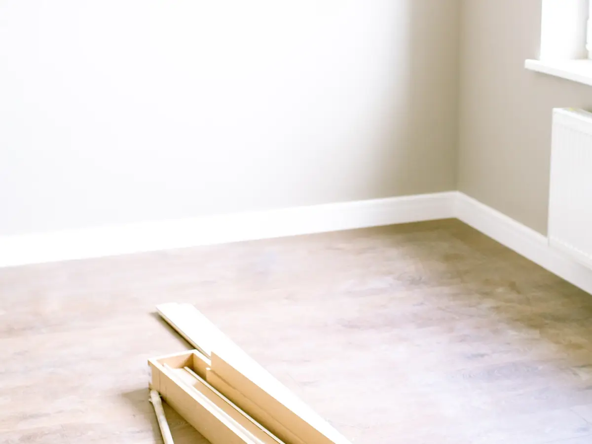 Empty room with boards and a broom after a strip-out