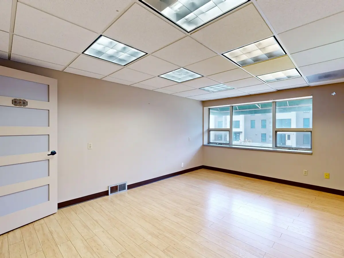 Vacant office with a suspended ceiling grid and carpet