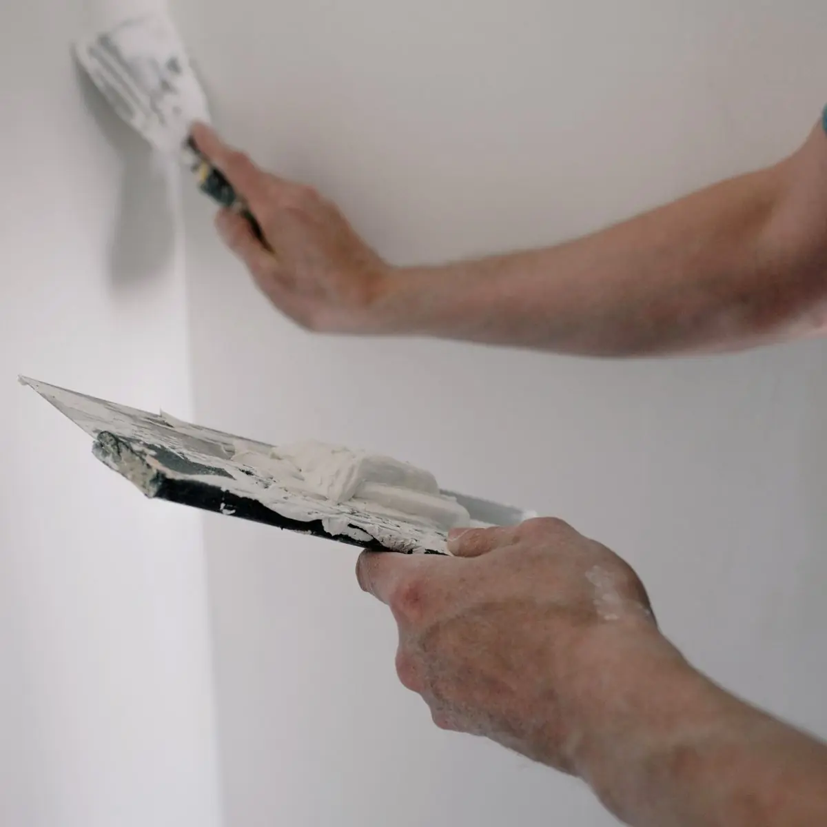Plaster being laid on to an internal corner with a trowel