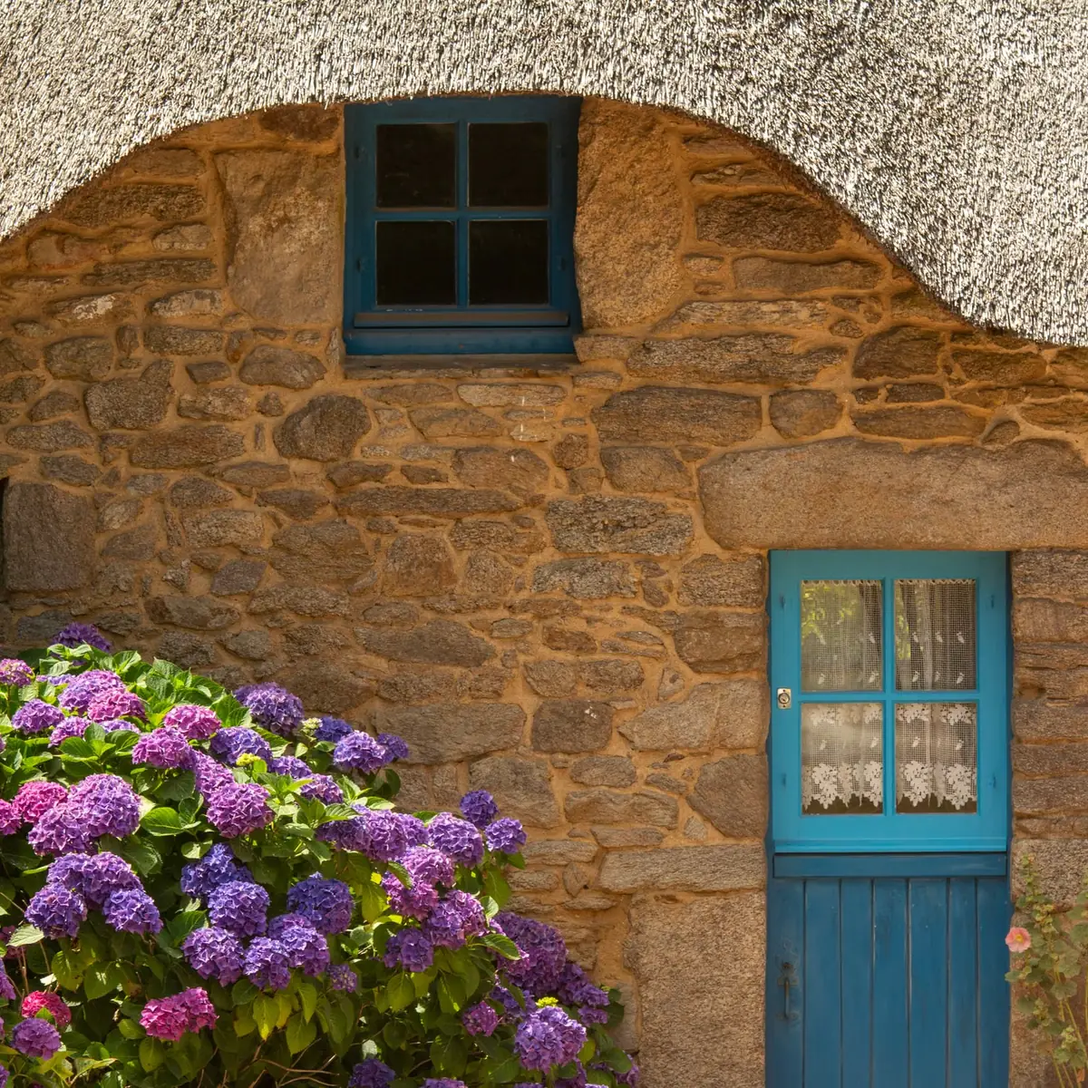 Stone cottage wall with a blue window