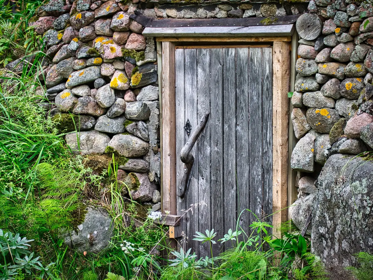 Weathered timber door set in a drystone wall