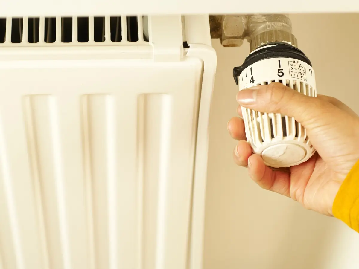 Hand adjusting a radiator thermostat