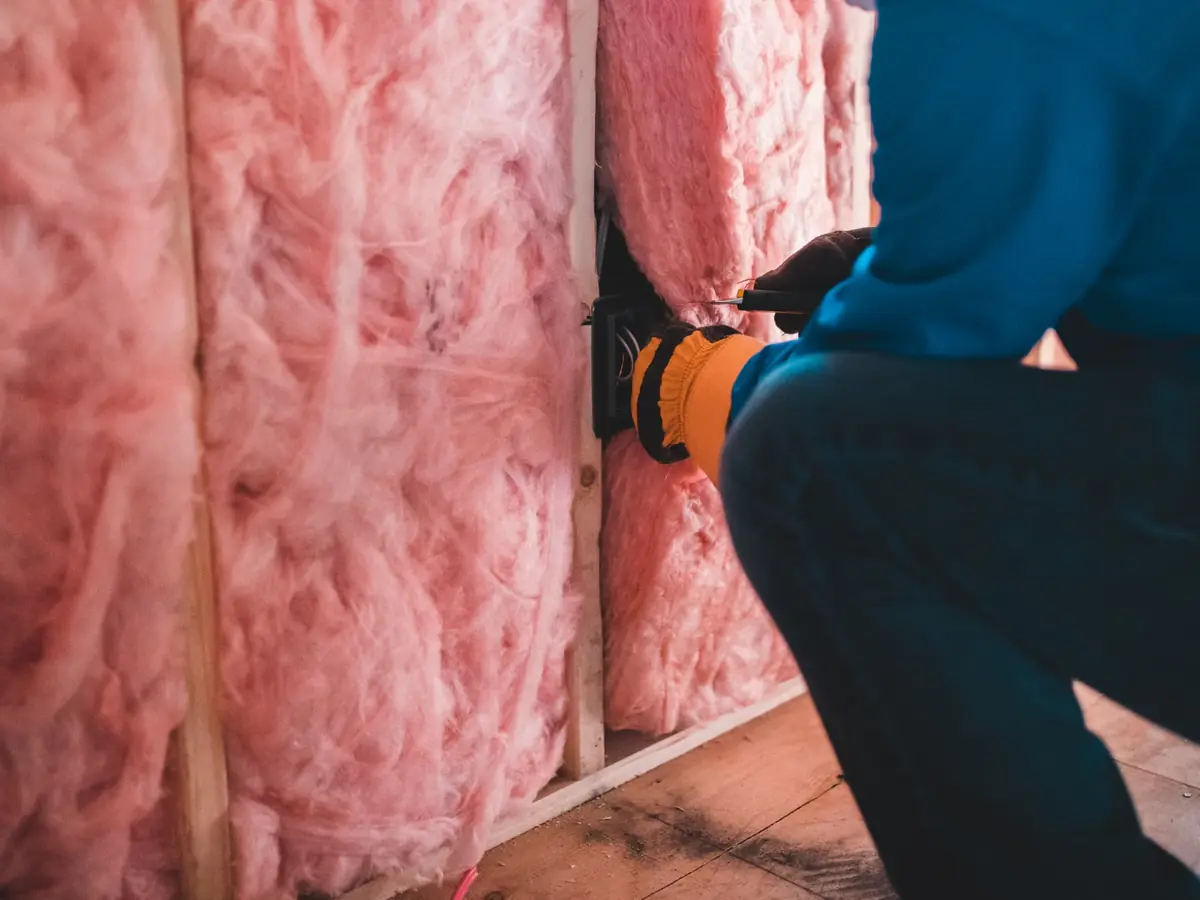 Mineral wool insulation being packed between timber studs