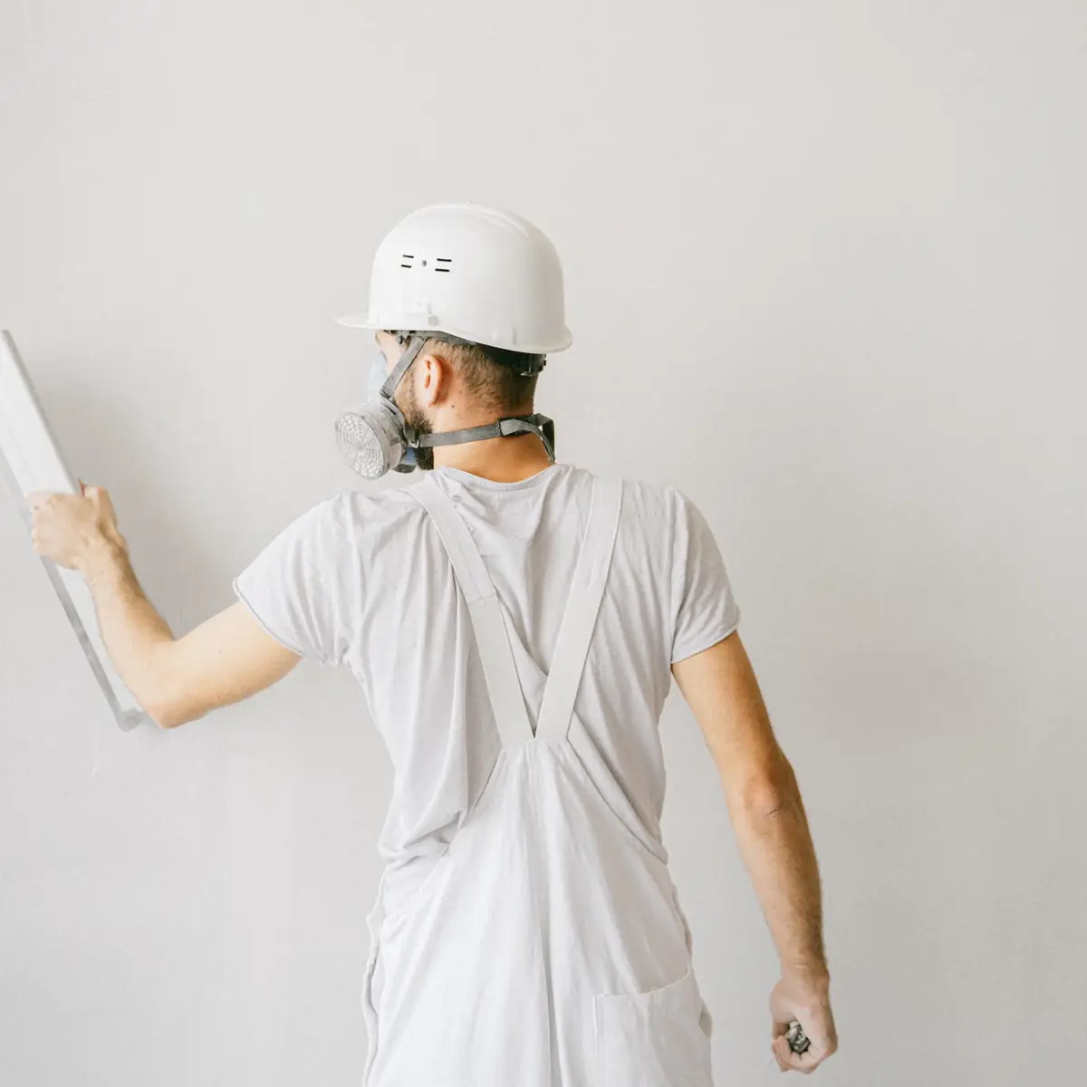 Plasterer working across a white wall
