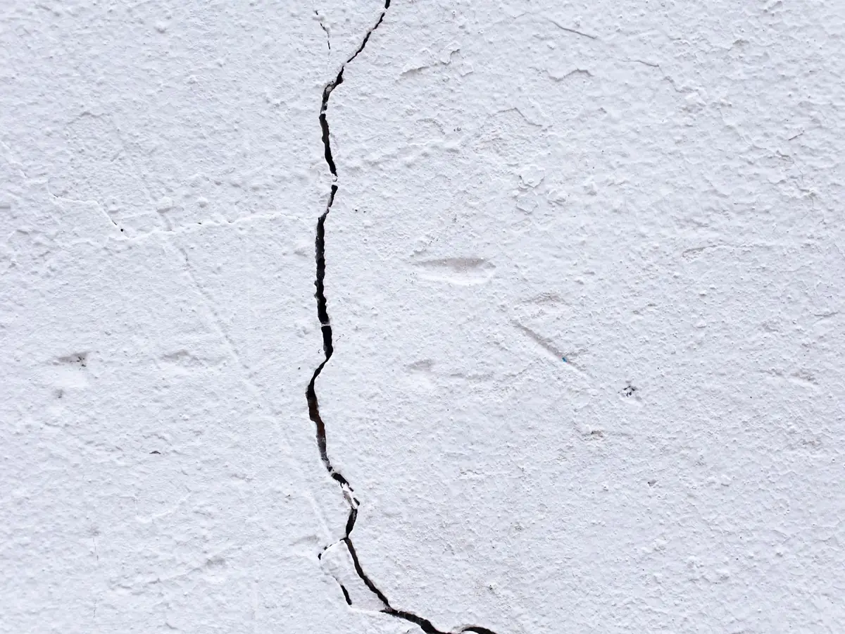 Old plaster wall with a large crack running through it