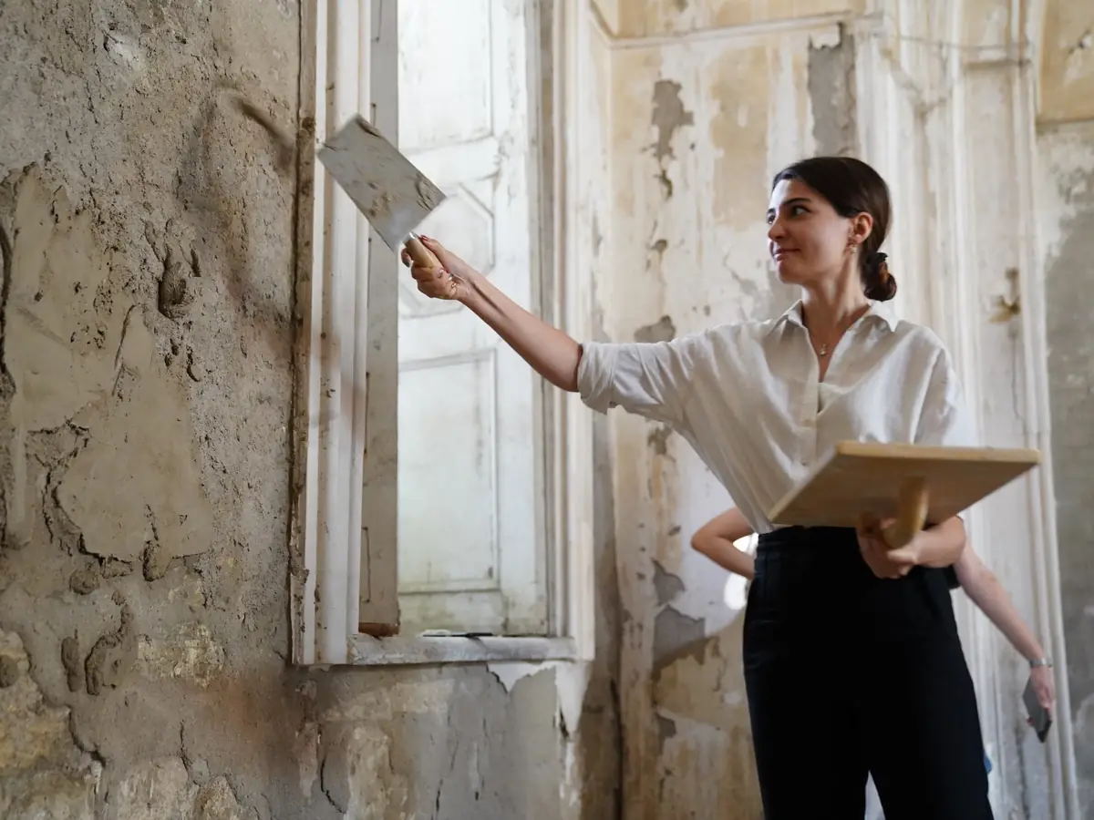 Plasterer restoring an old interior wall by hand