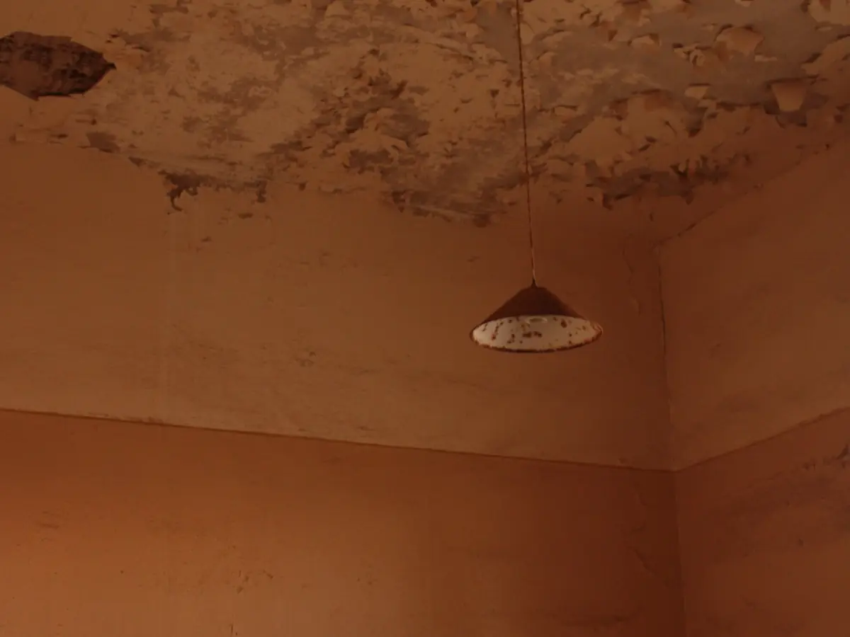 Old damaged ceiling with a hanging pendant light