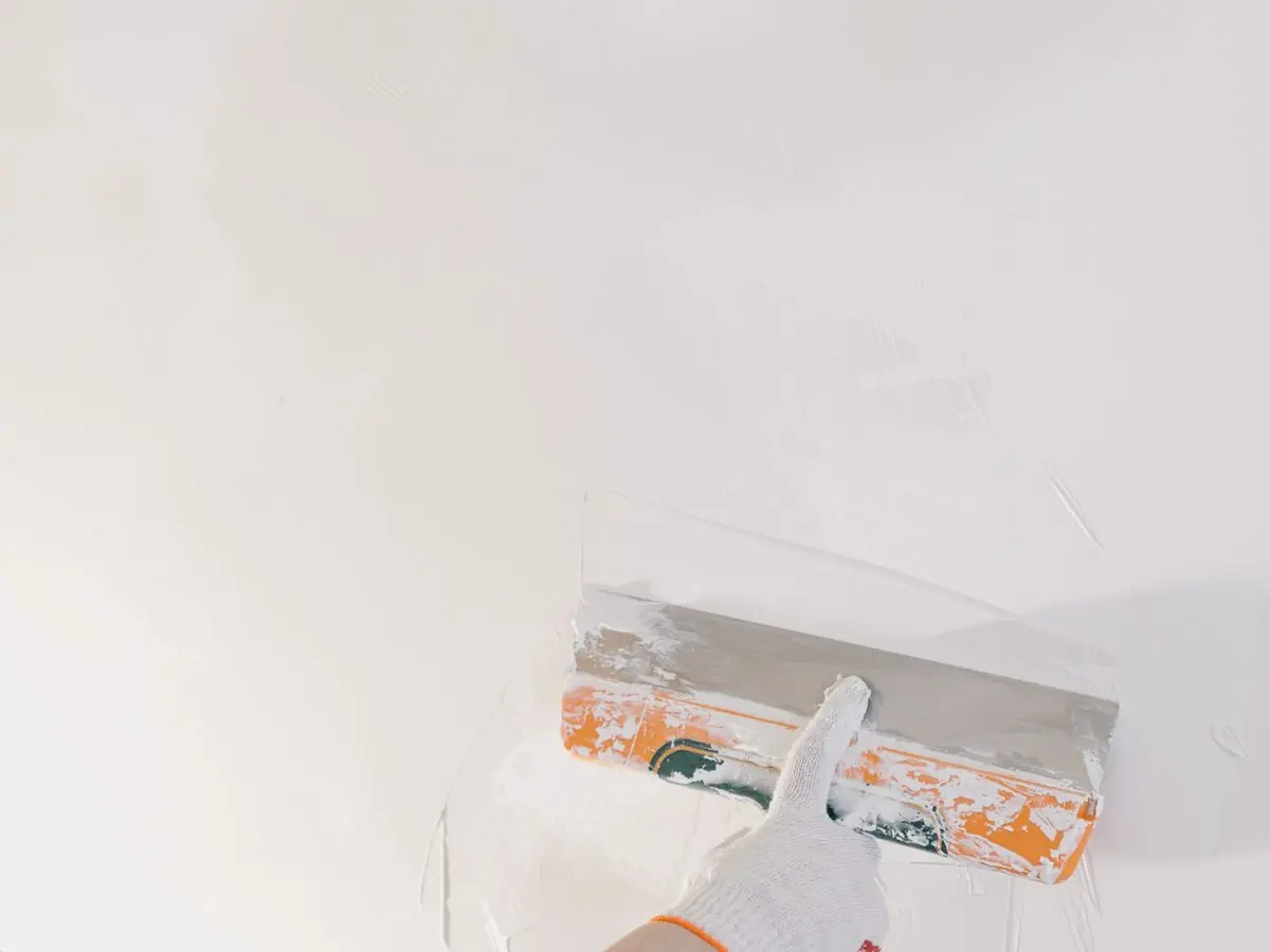 Trowelling the final coat of plaster on a wall