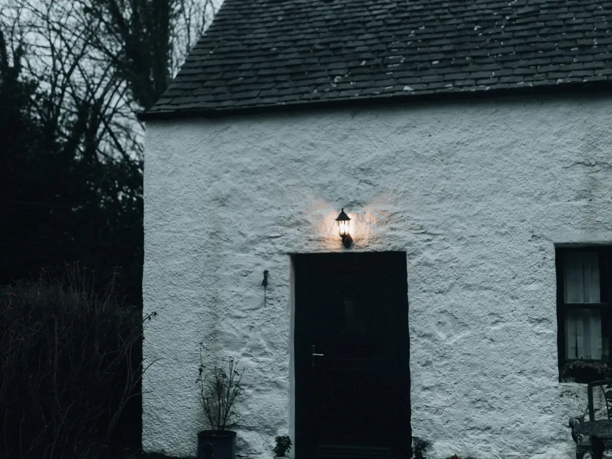White lime-rendered cottage under a slate roof