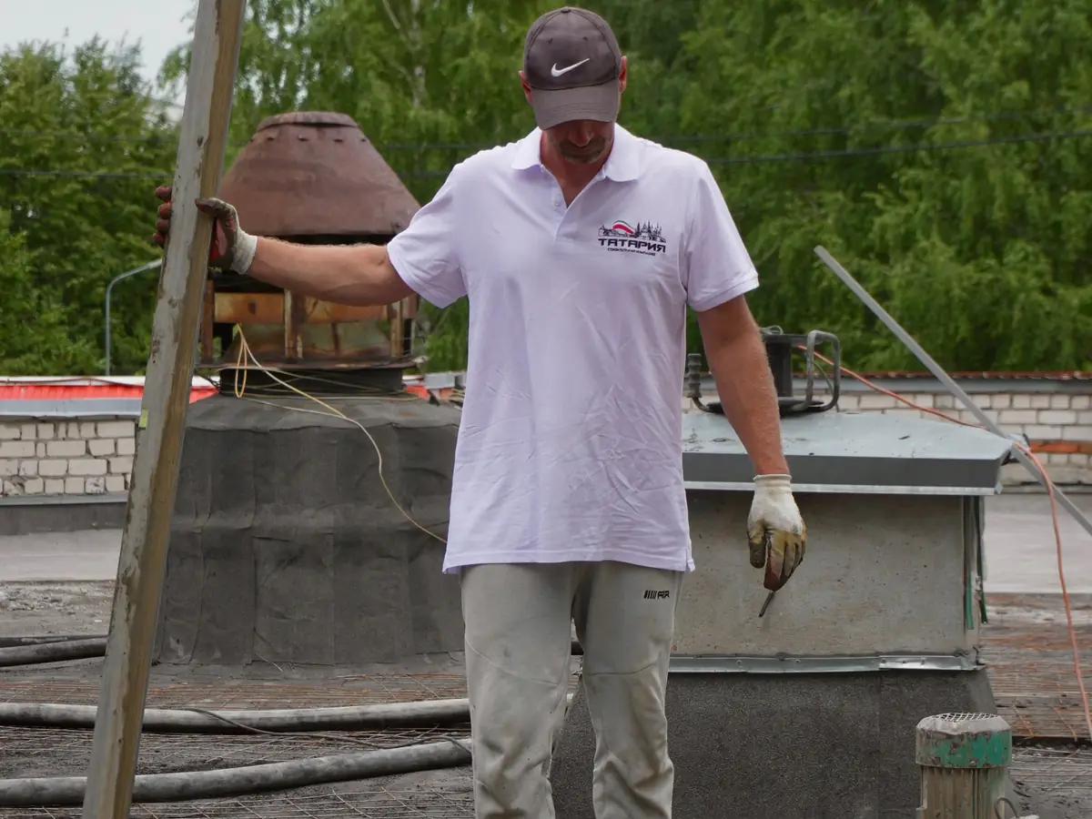 Screeder levelling a freshly laid floor with a long straight edge