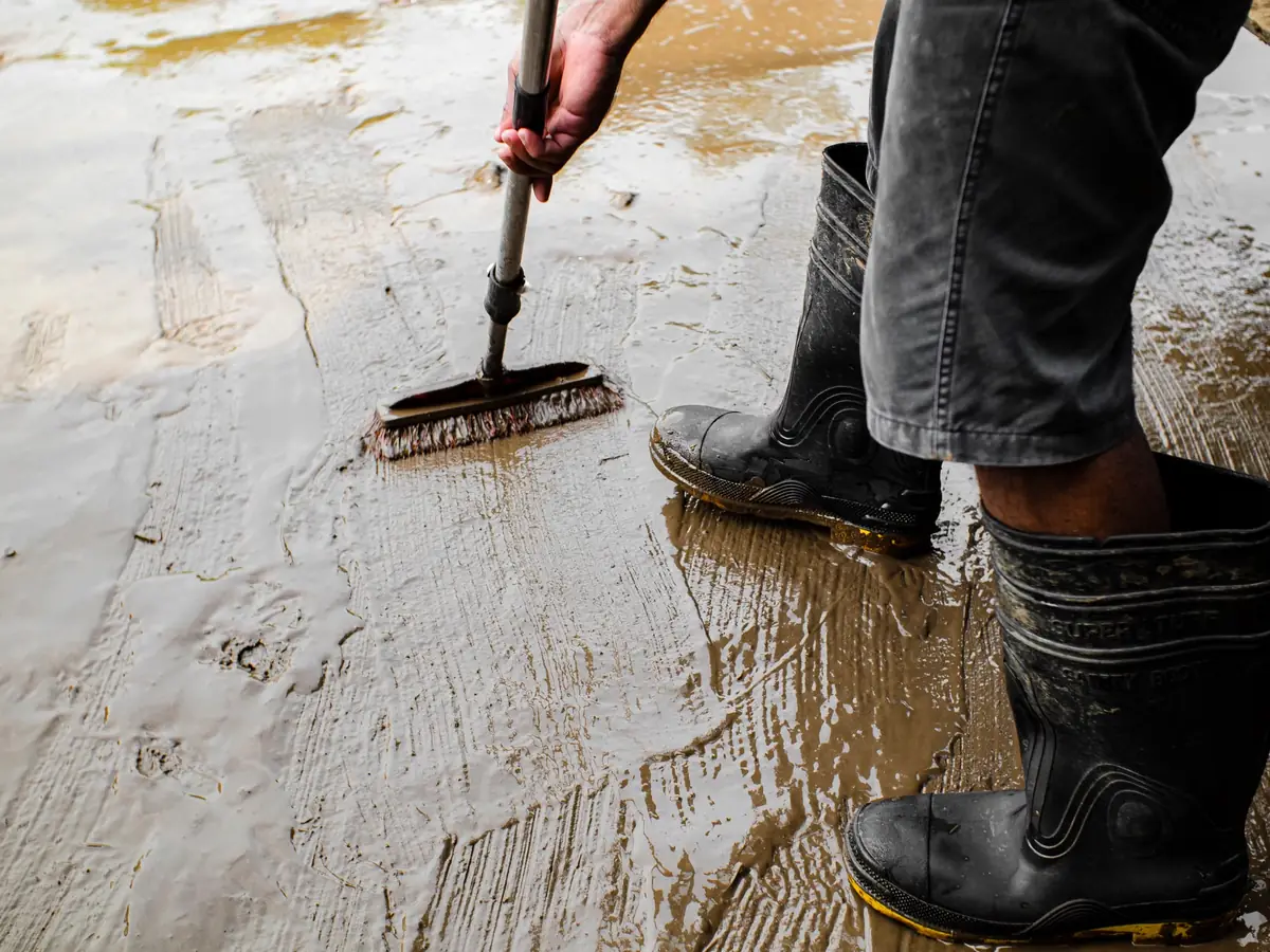 Priming a concrete floor with a brush before a levelling layer