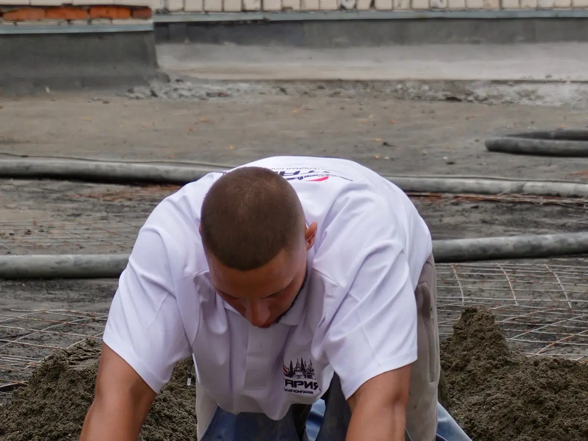 Screeder working a floor by hand with a float