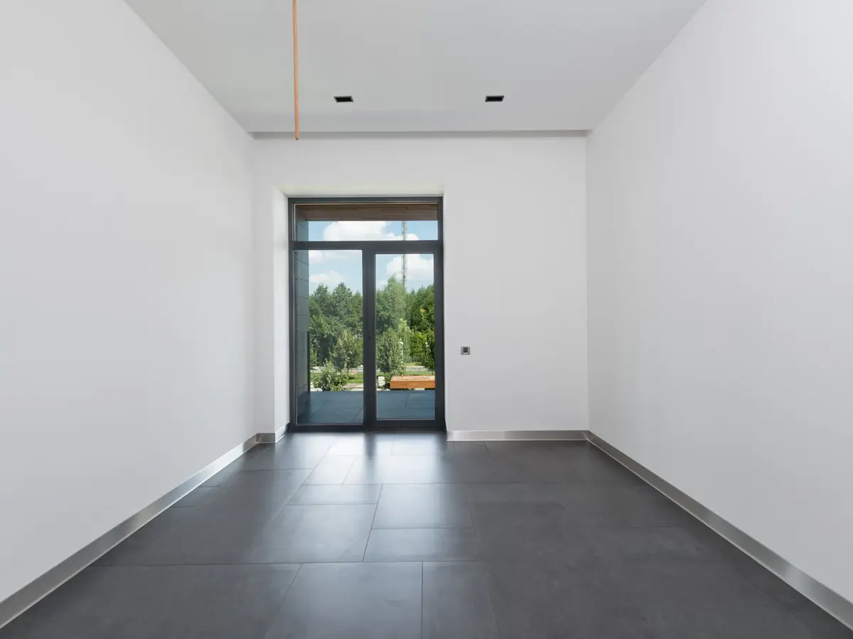 Empty commercial room with a new level floor and full-height glazing