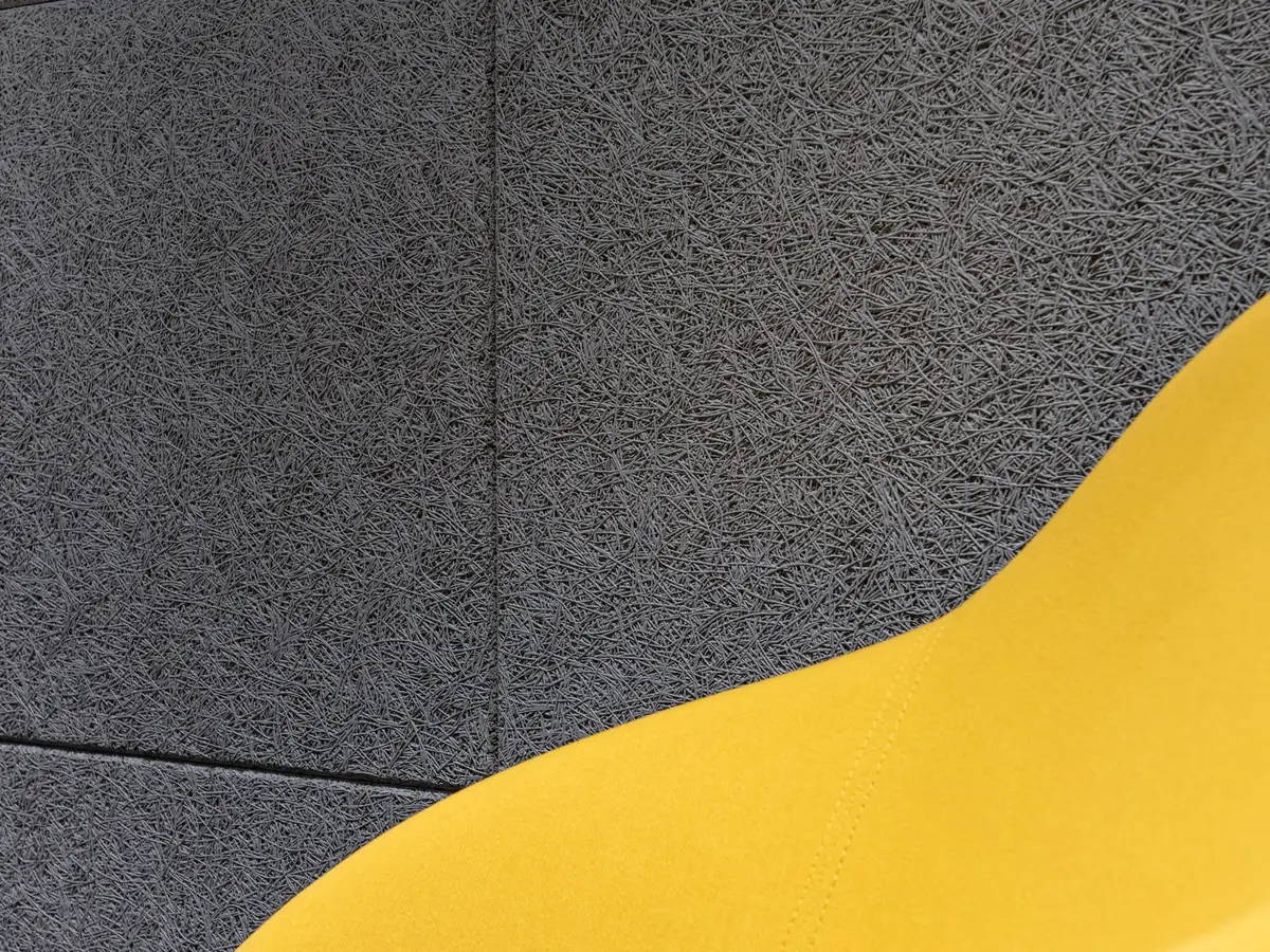 Armchair against a grey acoustic wall panel