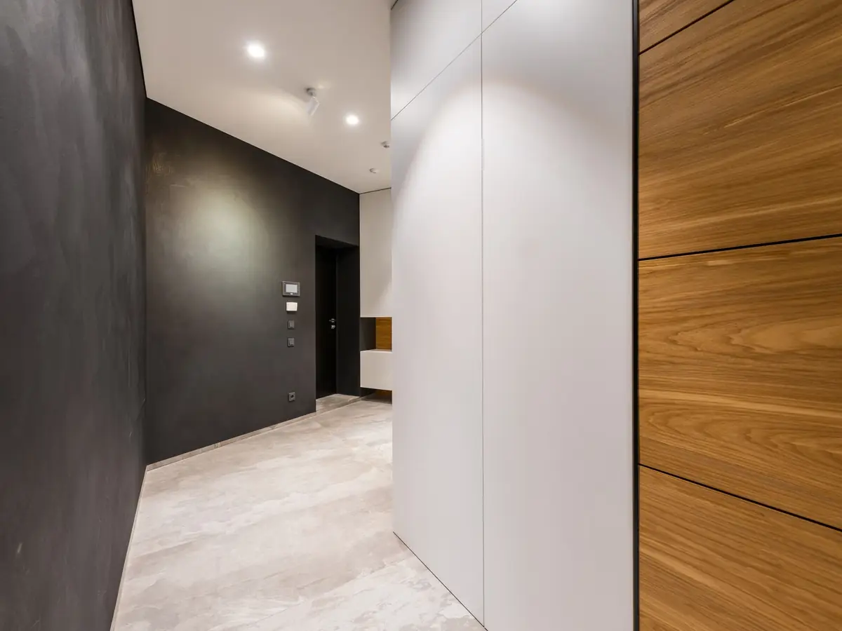 Dark polished plaster hallway with a lit doorway